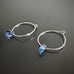handmade sterling silver hoop earrings with a small blue Austrian crystal teardrop
