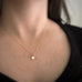 Tiny 14k gold filled ginkgo leaf pendant necklace shown on model.
