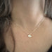 Tiny sterling silver ginkgo leaf pendant necklace on model.