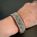 hand woven sead beads with subtle leaf pattern stitched to a brown leather strap