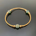 gold tube stretch bangle bracelet with green ancient looking glass