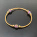 gold tube stretch bangle bracelet with purple ancient looking glass