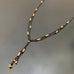 Y shaped necklace made with black chain and gold beads