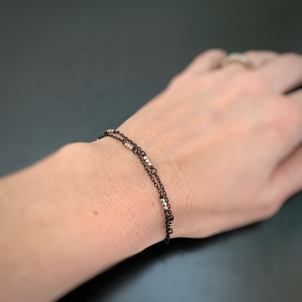 double strand adjustable length bracelet made with black chain and silvery beads
