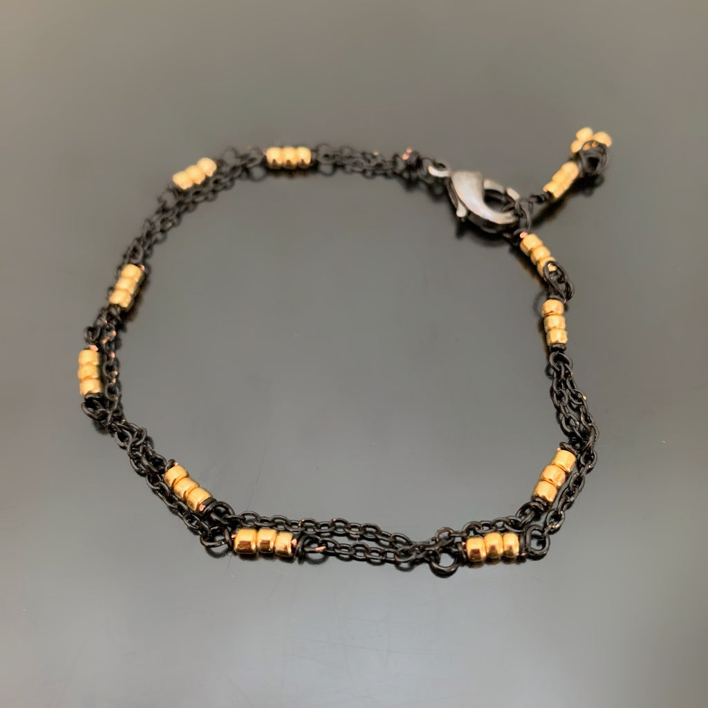 double strand adjustable length bracelet made with black chain and gold beads