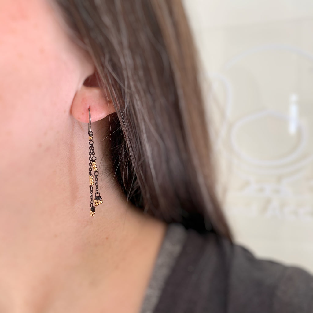 delicate and lace like earrings with black chain and gold beads