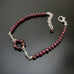 garnet bracelet with a circular link and glass accents at center