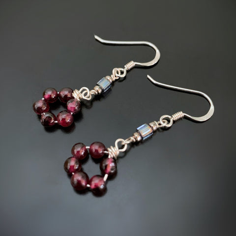 a circle of garnet beads on drop silver earrings