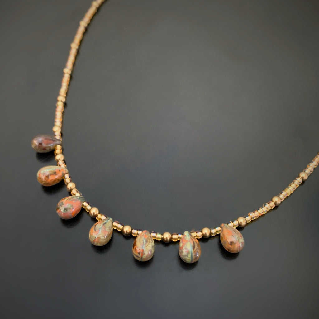 earthy glass teardrops adorn this gold accented adjustable length choker necklace