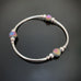 silver tube stretch bangle bracelet with purple ancient looking glass