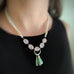 three drops of ruby in zoisite hang from a hand made sterling silver element and accented with rose quartz and freshwater pearls. in the beaded necklace.