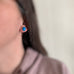 Blue turquoise oval stud earrings in sterling silver shown on model.