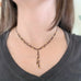 lace like y shaped necklace with black chain and golden beads
