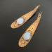 Long Golden Teardrop Earrings with Moon Glow Opal Glass and Lotus Flower Motif