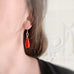 opaque red teardrop earring swith sterling silver ear wires and a twisted ring motif