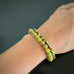 Set of two stretch bracelets, one in olivine green jade, and one in green and brown striped glass