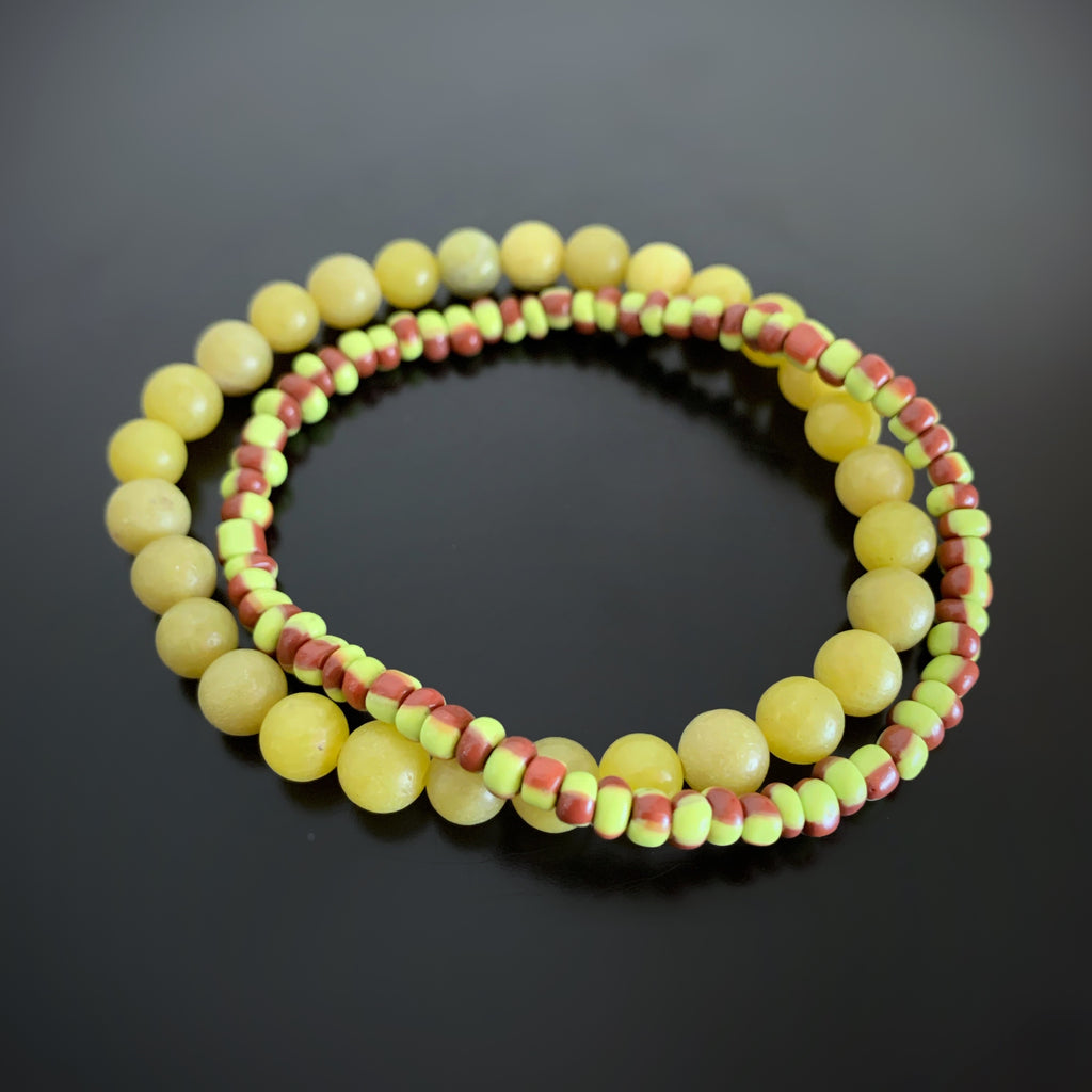 Pair of stretch bracelets, one in olivine green jade, and one in green and brown striped glass