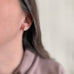 Pink rose quartz oval stud earrings in sterling silver shown on model.