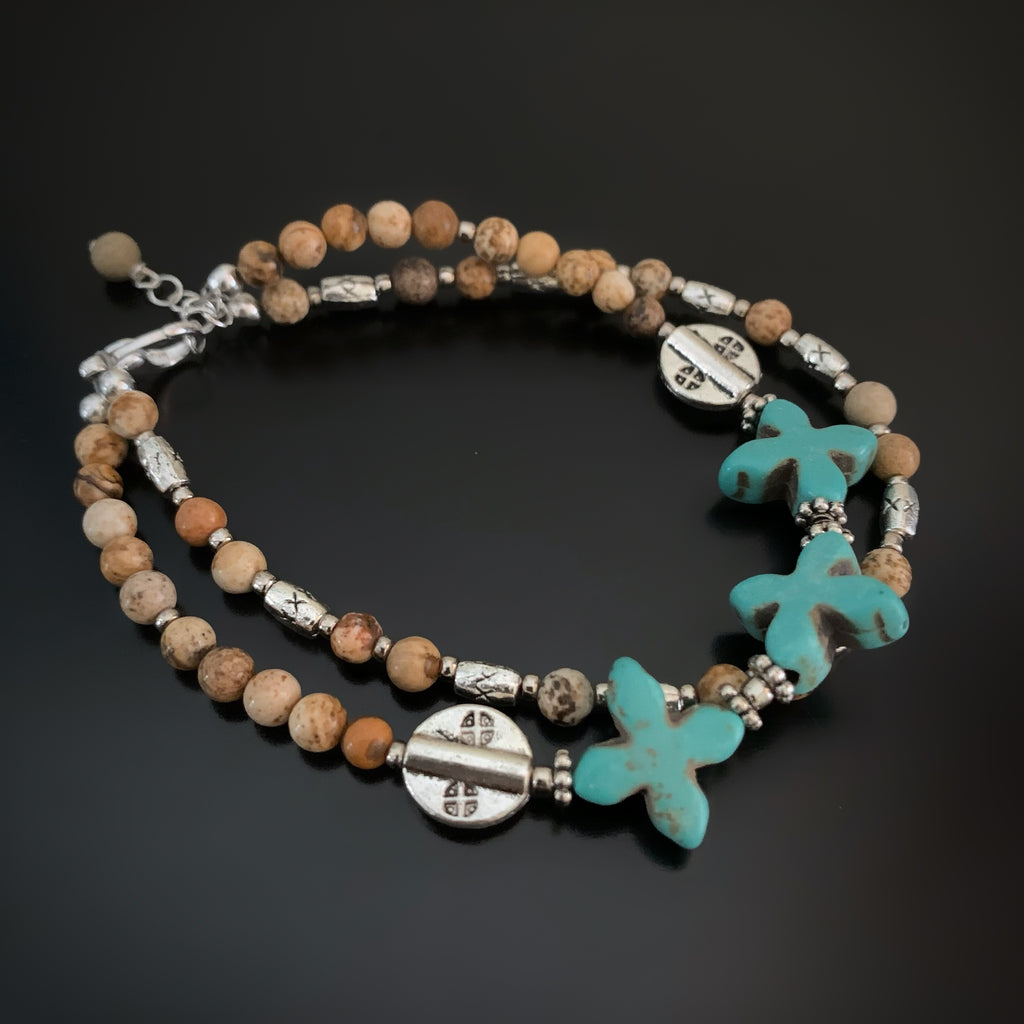 silver, turquoise and tan beaded two strand bracelet with a southwest cross design