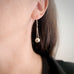 Sterling silver ball drop earrings with chain shown on model.