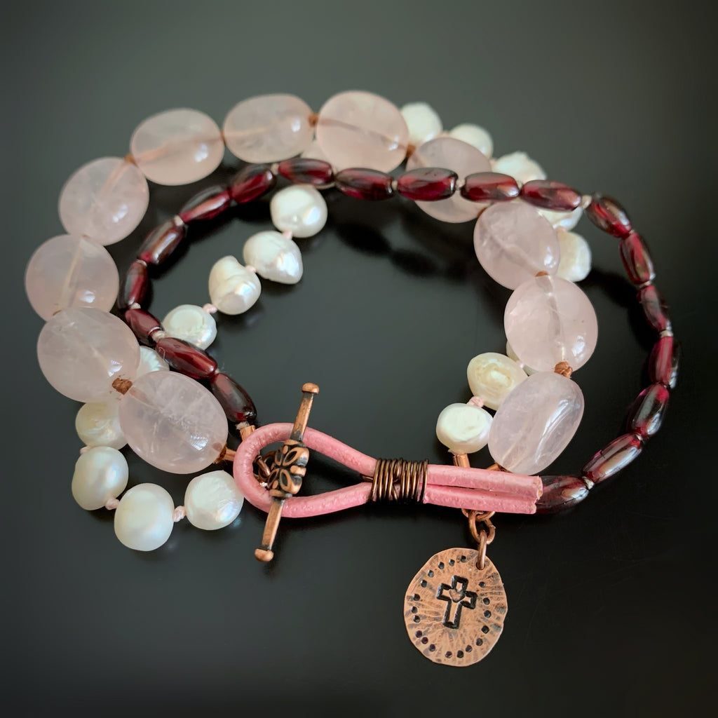 hand knotted bracelet with rose quartz, garnet, freshwater pearl and features a hand made copper charm with a cross and heart