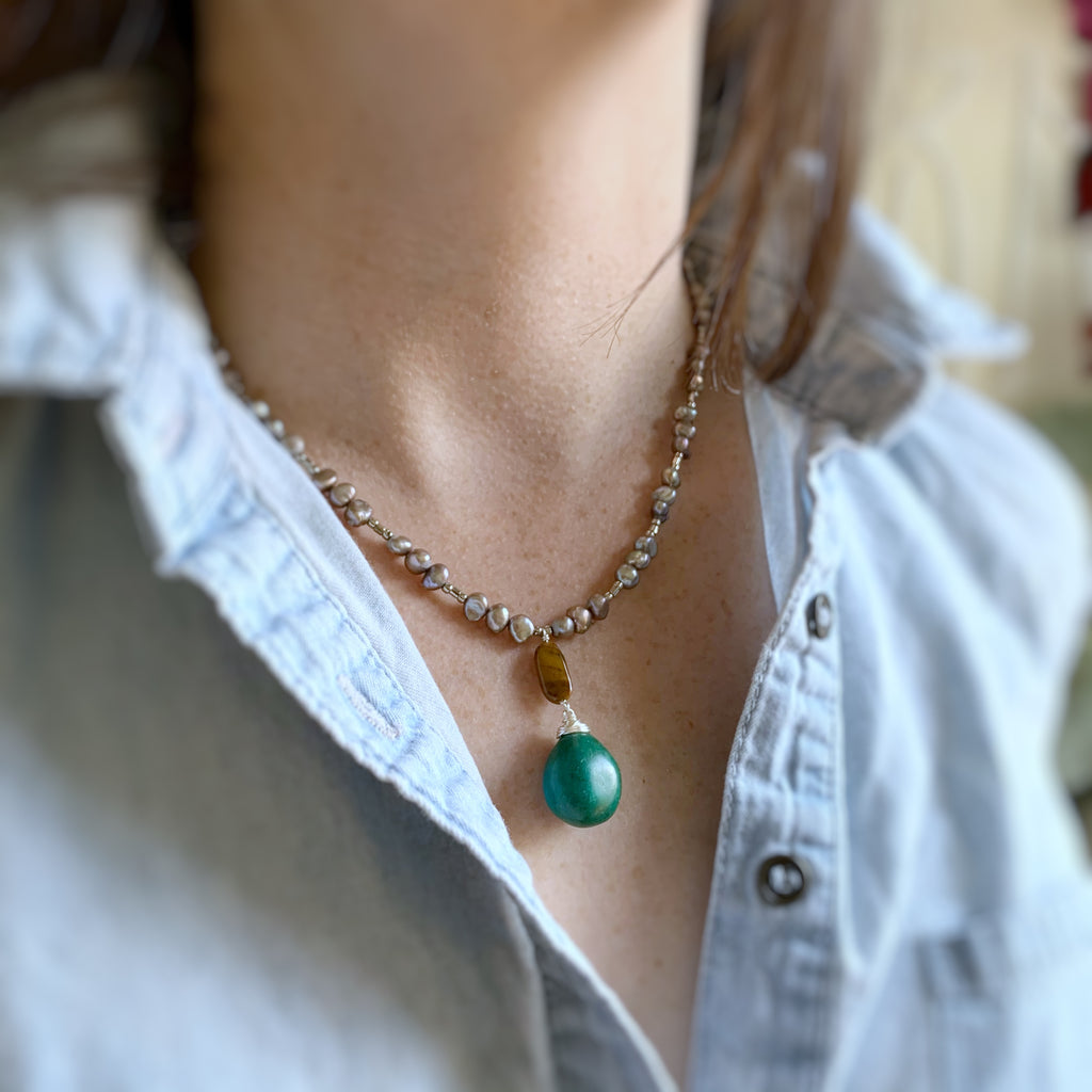turquoise and tiger eye drop on a warm grey freshwater pealr necklace